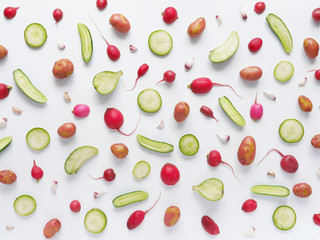 Vegetables on a white background. Pattern of vegetables. Abstract food background. Collage of food. Top view. Composition from potato, green pepper, cucumber, green radish, tomatoes, pink radish.