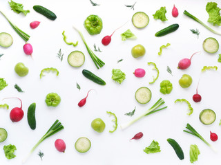 Vegetables and fruits on a white background. Pattern of vegetables and fruits. Abstract food background. Top view.  Food collage of  green radish, pepper, lettuce, cucumber, green apples, onion.