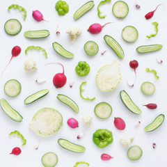 Vegetables and fruits on a white background. Pattern of vegetables and fruits. Abstract food background. Collage of food. Top view. Composition from cabbage, green pepper, cucumber, green radish, caul