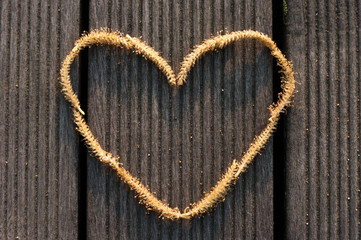 Abstract Heart shape made of a Willow male flower on the wooden floor