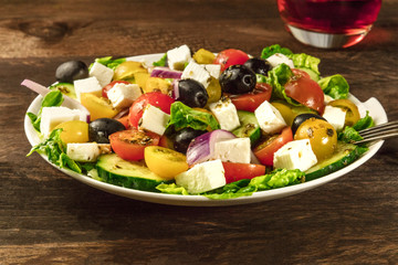 Greek salad with feta, fresh vegetables, and rose wine