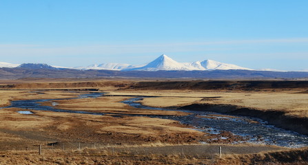 Icelandic landscape with mountains and snow in the distance