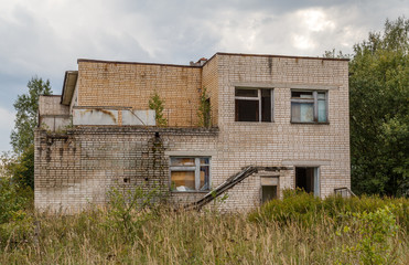 Abandoned house of white brick with broken windows