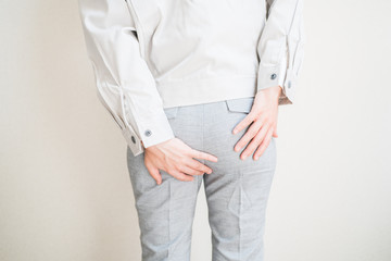 おしりを抑える女性労働者
