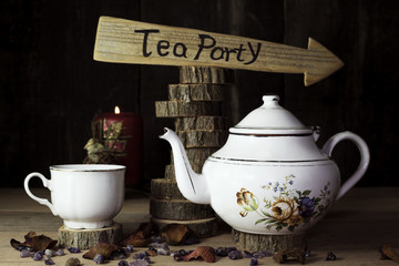 Tea Party. Cup of Tea and Teapot On Wooden Table With Arrow Sign in the Background