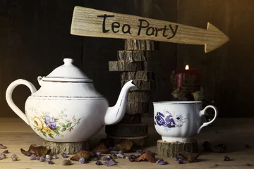 Foto op Aluminium Tea Party. Cup of Tea and Teapot On Wooden Table With Arrow Sign in the Background © ArtmediaworX