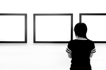 Woman watching blank photo frame on wall art gallery, art exhibition.