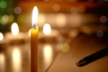 Candles light with blurred book background in the Church