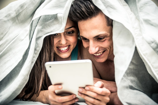 Couple watching movie in bed