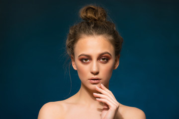 Portrait of beautiful cheerful young woman on blue background