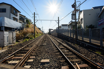 Fototapeta na wymiar 青空の下、住宅街の中を走る日本の鉄道 