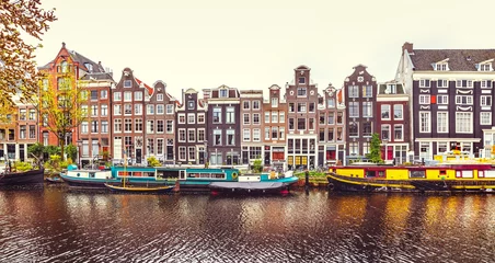 Foto op Aluminium Dansend huis in Amsterdam Nederland over rivier de Amstel © Yasonya