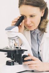 Scientist using microscope in laboratory.