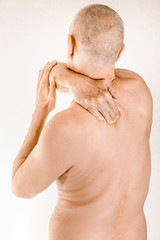 Man massaging his top back, the trapezius muscle, because of a thoracic vertebrae pain due to a...