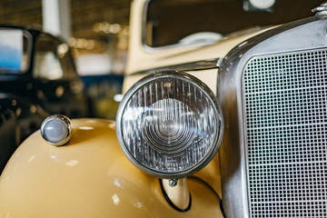 Headlight of the vintage cream car