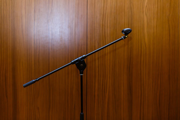 A microphone on the stand on a wooden background, black and white photo