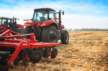 Red tractor in the field on a bright sunny day.