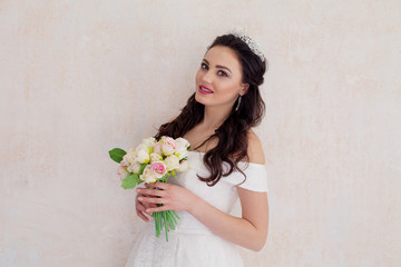 bride Princess stands in a wedding dress with flowers