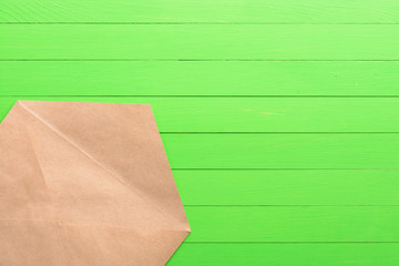 Brown envelope on green wooden background