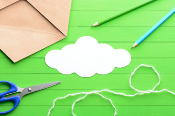 Sticker in the shape of a cloud with the envelope on green wooden background