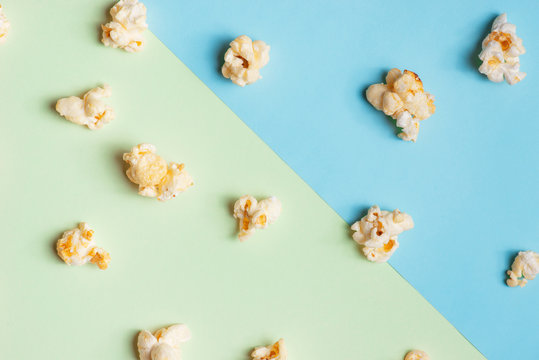 The popcorn in paper cup on green and blue background.