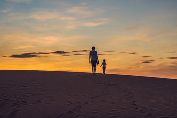 Father and son at the red desert at dawn. Traveling with children concept