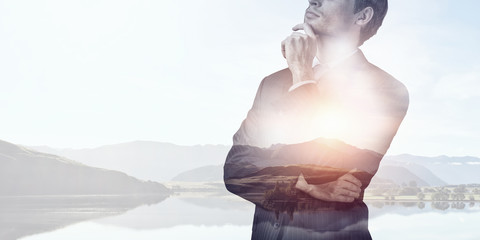 Businessman against nature background . Mixed media