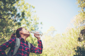 Close up of young hiker drinking water at mountain.