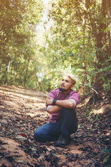 Young man hiker looking to the side walking in forest. Enjoy with nature.