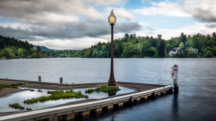 A dock and lamp post on a cloudy afternoon in the Adirondacks on Lake Flower at Saranac Lake, New York