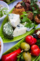 Snacks, Käse und Fingerfood mit frischem Gemüse und Fleischbällchen für eine Gartenparty auf einem Leinentuch