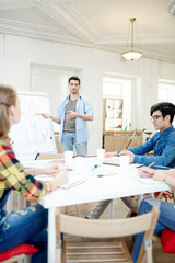 Clever guy pointing at chart on whiteboard at lesson