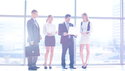 Portrait of young businesswoman in office with colleagues in the background