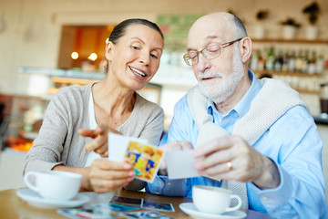 Happy couple looking through photos of their grandchildren