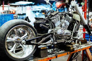 Background image of big disassembled motorcycle on stand in workshop, ready for repair, tune up and...