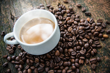 Hot cub of coffee and bean on wooden background