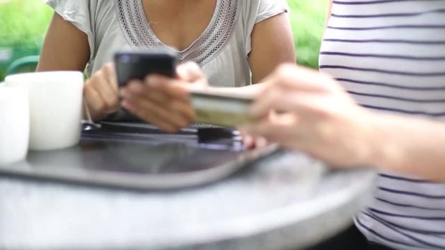 Women using smartphone and credit card to shop online