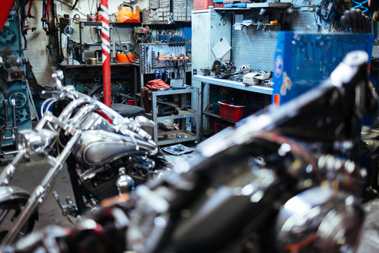 Background image on empty mechanics workshop with motorcycles waiting for repairs