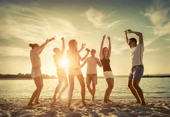 Foto op Plexiglas Friends funny dance on the beach under sunset sunlight. © Andrii IURLOV