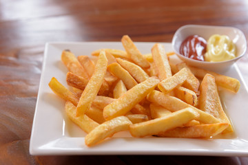 French fries in a bowl on a wooden background