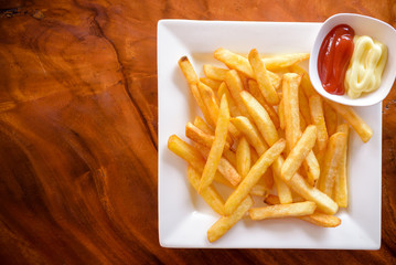 French fries in a bowl on a wooden background