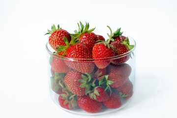 Strawberries in a glass on a white background. Side view