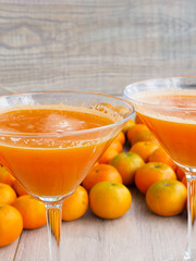 freshly squeezed tangerine juice in glass on rustic wooden background