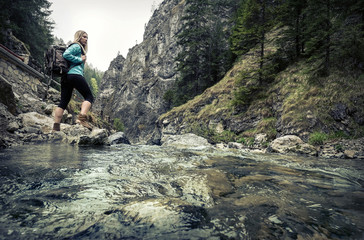 Woman hiking around mountains near the river at spreeng time.