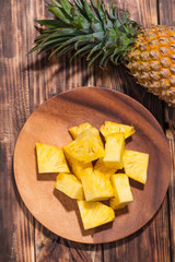 Tropical fruit concept. Cutted pineapple on the old wooden background.