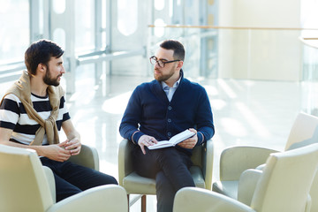 Two young businessmen discussing their working plans