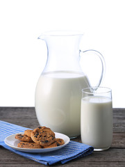 Pitcher and glass with some milk and cookies