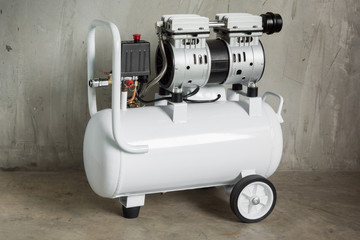 white air compressor against concrete floor and wall