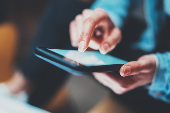 Closeup View Of Woman Holding Modern Smartphone In Hands.Girl Typing On White Touch Mobile Screen. Horizontal, Blurred Background, Bokeh Effects.Macro.