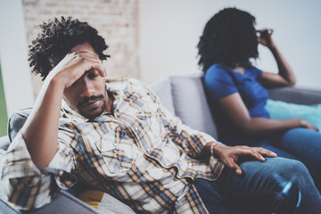 Young sad black couple.Upset man being ignored by partner at home in the living room.American...